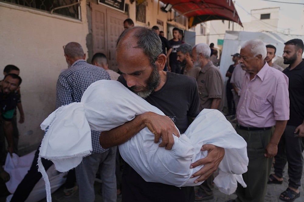 Ahmed Al-Hajj carries the body of his daughter, Dana Al-Hajj, 13, who was killed in an Israeli airstrike in the Gaza Strip, at Al-Aqsa Hospital in Deir al-Balah, Tuesday, Aug. 19, 2025. (AP)