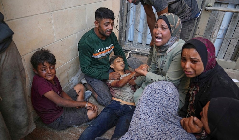 People mourn over the body of a young Palestinian killed while trying to reach trucks carrying humanitarian aid en route to Gaza City, outside the Hamad Al-Qatari Hospital in Beit Lahia, northern Gaza Strip, Friday, Aug. 1, 2025. (AP)