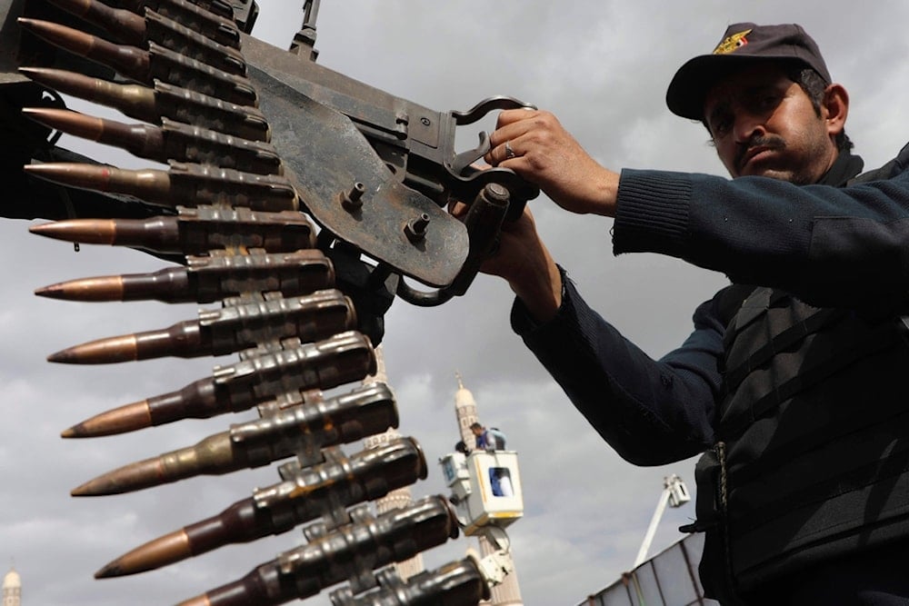 A Yemeni soldier stands alert on the sidelines of a weekly protest against the US and 