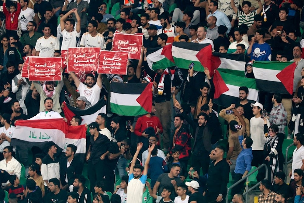 Iraq supporters wave the Palestinian flag during the 2026 FIFA World Cup AFC qualifiers football match between Iraq and Indonesia at the Basra International Stadium, in Basra, Iraq, Thursday, November 16, 2023 (AP)