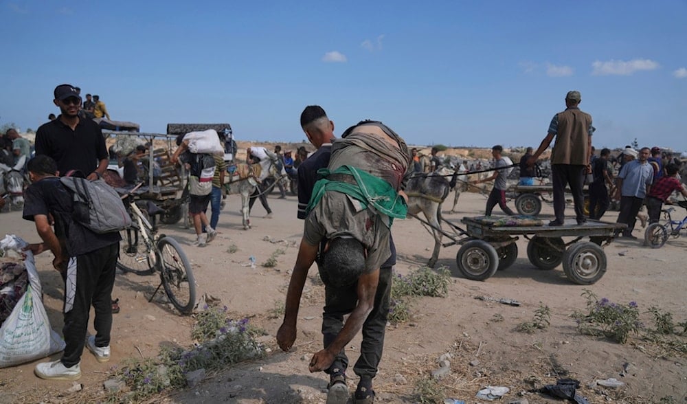 A Palestinian carries the body of a man killed while trying to receive aid near a distribution center operated by the U.S.-backed Gaza Humanitarian Foundation in Netzarim, in the Gaza Strip, Aug. 4, 2025. (AP)