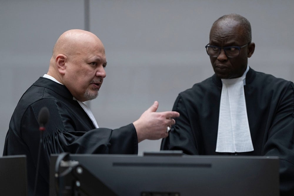 Chief Prosecutor Karim Khan, left, talks to Deputy Prosecutor Mame Mandiaye Niang at the International Criminal Court (ICC) in The Hague, Netherlands, Friday, March 14, 2025 (AP)