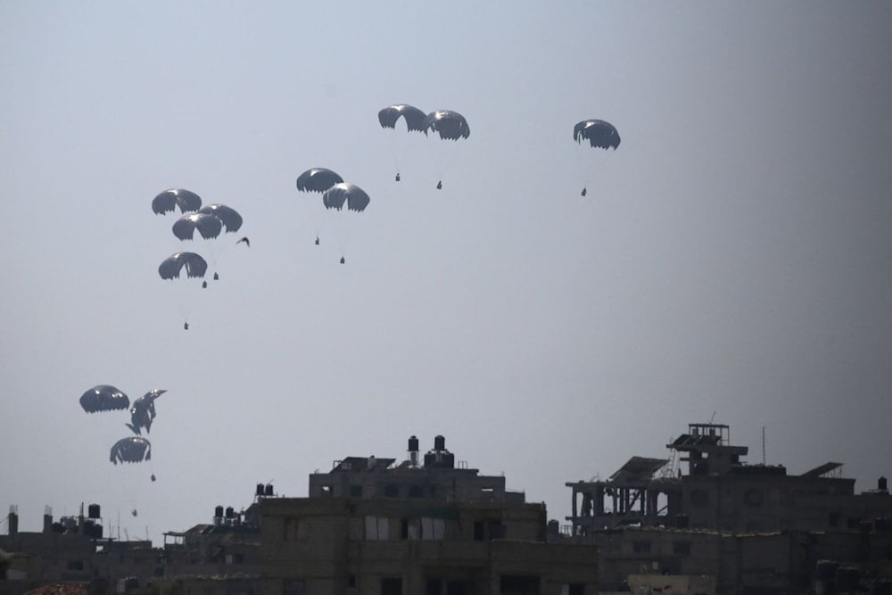 A military transport aircraft drops humanitarian aid over Al-Zawayda, in the central Gaza Strip, on July 28, 2025. (Eyad Baba / AFP)