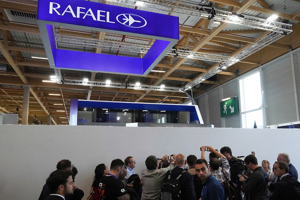 Reporters gather around Shlomo Toaff, of the Israeli Rafael Advanced Defense Systems, at the Paris Air Show, Monday, June 16, 2025 in Le Bourget, north of Paris (AP)