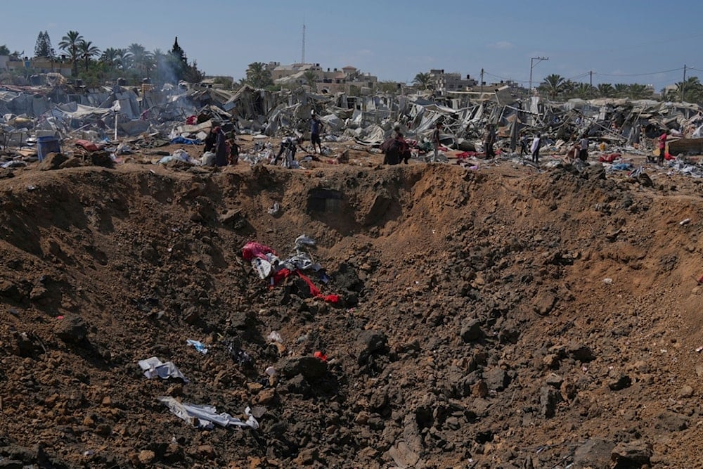 Palestinians check the destruction next to a crater after Israeli military strikes in a tent camp for displaced people near Al-Aqsa Hospital, in Deir al-Balah, Thursday, Aug. 21, 2025. (AP)
