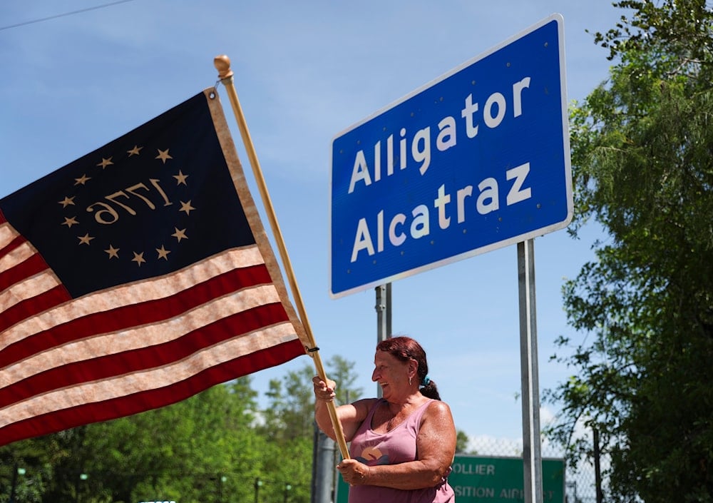 Rana Mourer waves an American flag outside of the migrant detention facility dubbed 