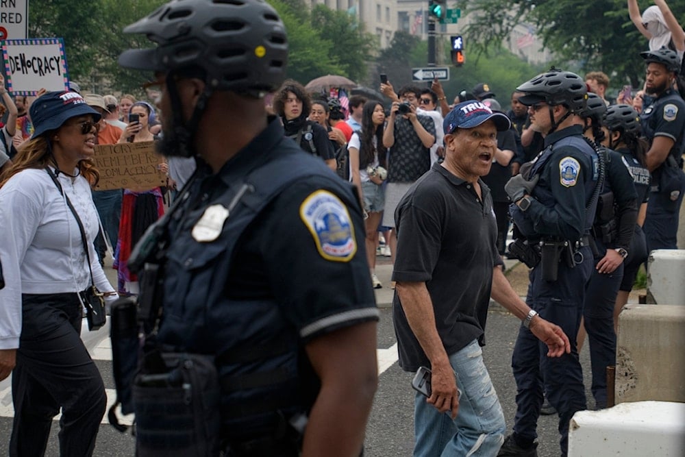 A man walks through a buffer zone created by Washington DC Metro police during a protest taking place on the day of a military parade commemorating the Army's 250th anniversary, Saturday, June 14, 2025, in Washington (AP)