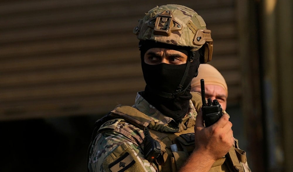 A Lebanese army officer, speaks on his radio as he deploys at the entrance of Burj al-Barajneh Palestinian refugee camp where Palestinian factions handed over weapons to the Lebanese army, in Beirut, Thursday, Aug. 21, 2025. (AP)