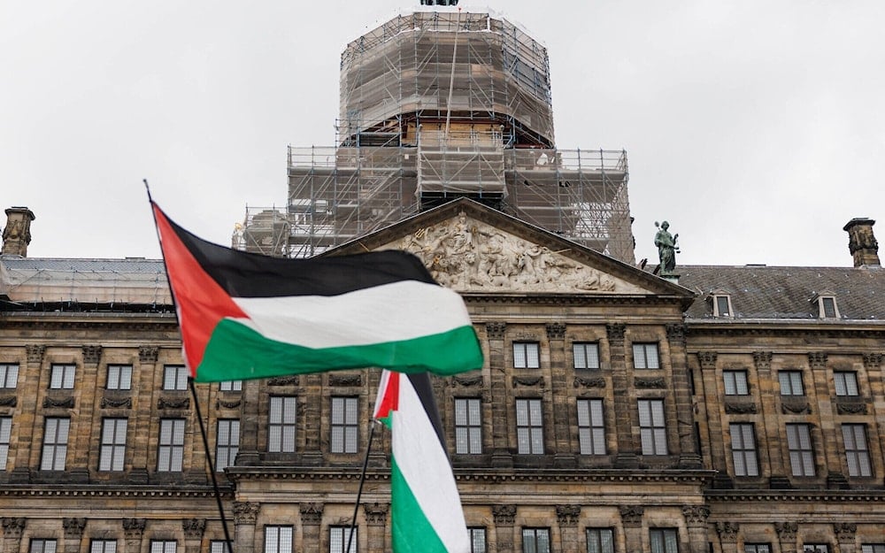 Palestinian flags flutter in the wind on Dam Square with the Royal Palace of Amsterdam in the background (Paleis op de Dam), in Amsterdam, on November 15, 2024. (Simon Wohlfahrt/AFP)