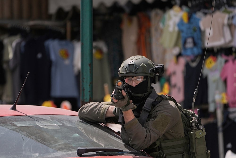 An Israeli soldier aims his weapon during a military raid in the West Bank city of Nablus, Tuesday, May 27, 2025 (AP)