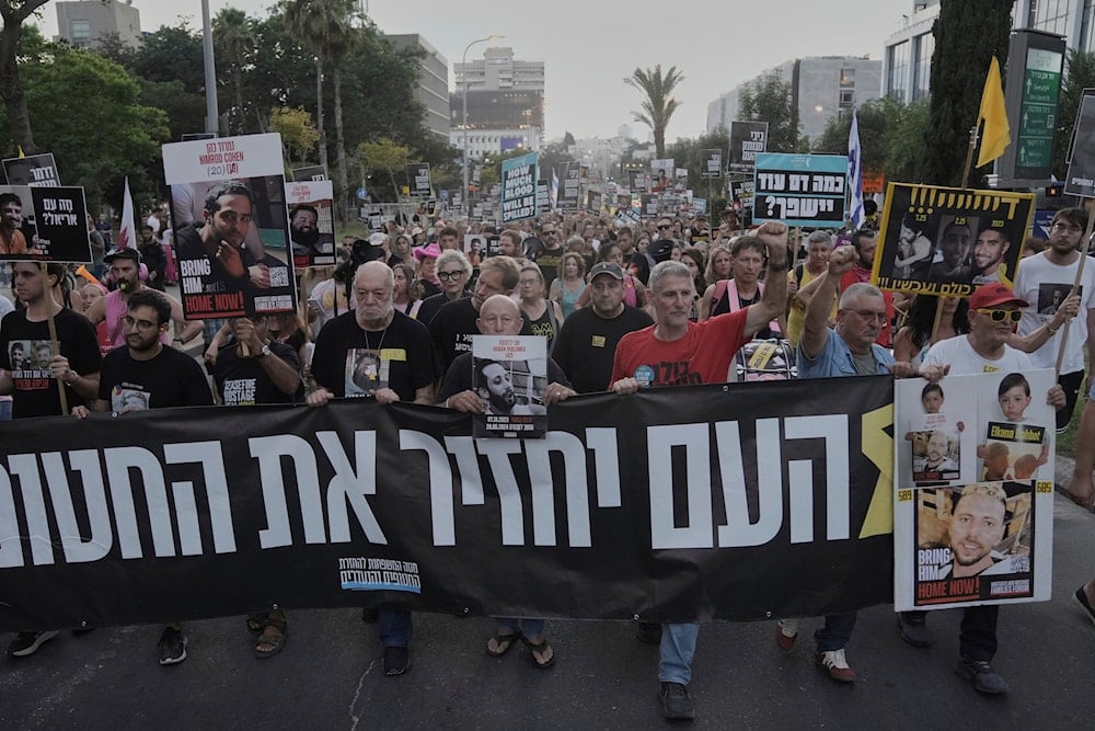 Relatives and supporters of Israeli captives in Gaza take part in a protest demanding their immediate release and calling for the end of the war in the Gaza Strip, as they march in Tel Aviv, Occupied Palestine, Thursday, Aug. 21, 2025 (AP)