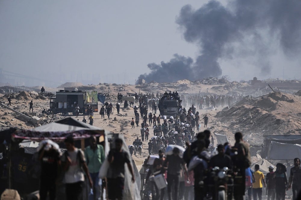 Palestinians carry sacks of flour unloaded from a humanitarian aid convoy on the outskirts of Beit Lahiya, northern Gaza Strip, Occupied Palestine, Saturday, Aug, 23, 2025 (AP)
