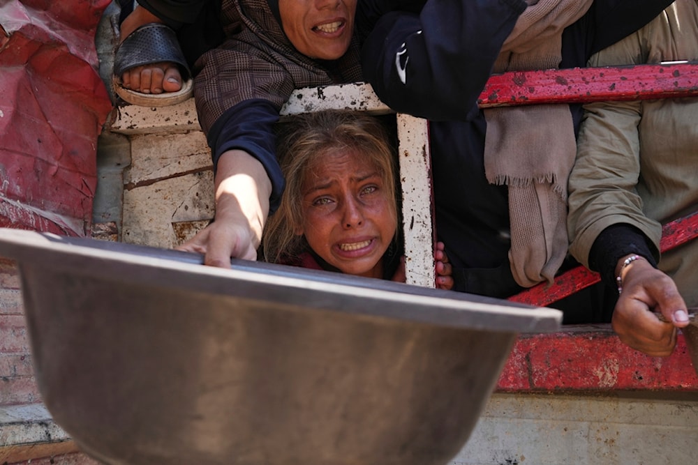 Palestinians struggle to receive donated food at a community kitchen in Gaza City, northern Gaza Strip, July 26, 2025. (AP Photo/Abdel Kareem Hana)
