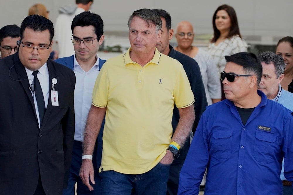 Brazil’s former President Jair Bolsonaro, center, temporarily allowed out of house arrest for medical exams, departs a hospital in Brasília, Brazil, Saturday, Aug. 16, 2025. (AP Photo/Eraldo Peres)