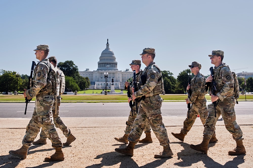 Armed National Guard soldiers from West Virginia patrol the Mall near the Capitol in Washington, as part of President Donald Trump's order to impose federal law enforcement in the nation's capital, Tuesday, Aug. 26, 2025. (AP Photo/J. Scott Applewhite)
