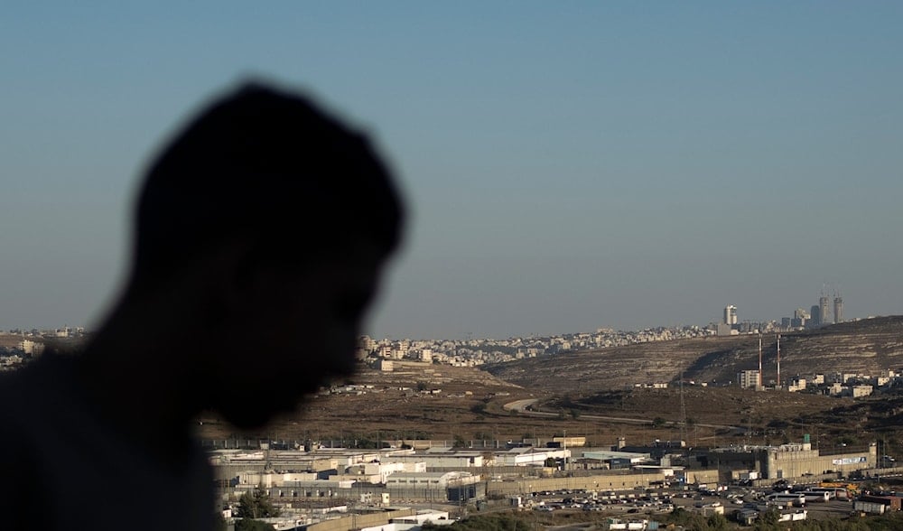 A Palestinian youth stands on a hill overlooking IsraelI Ofer Prison, near the West Bank city of Ramallah, Wednesday, July 3, 2024. (AP)