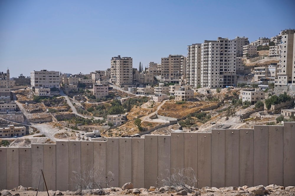 The separation wall next to the Arab neighborhood of al-Eizariya, near where the Israeli government says housing units will be built as part of the E1 settlement development project, Thursday, August 21, 2025 (AP)