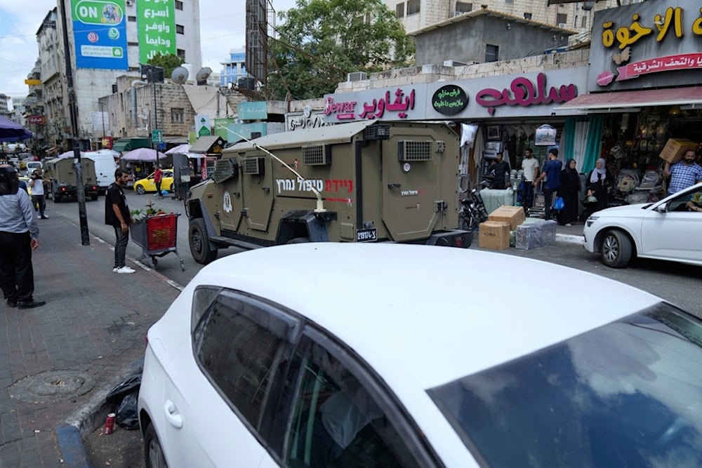 Israeli occupation forces vehicles raid currency exchange companies in the West Bank city of Ramallah, Tuesday, August 26, 2025 (AP)