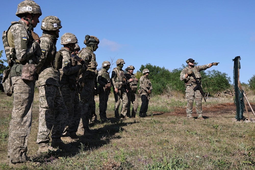 Recruits in Ukraine's 65th Mechanized Brigade practice military skills on a training ground in a sunflower field in the Zaporizhzhia region, Ukraine, Monday, Aug. 25, 2025 (AP)