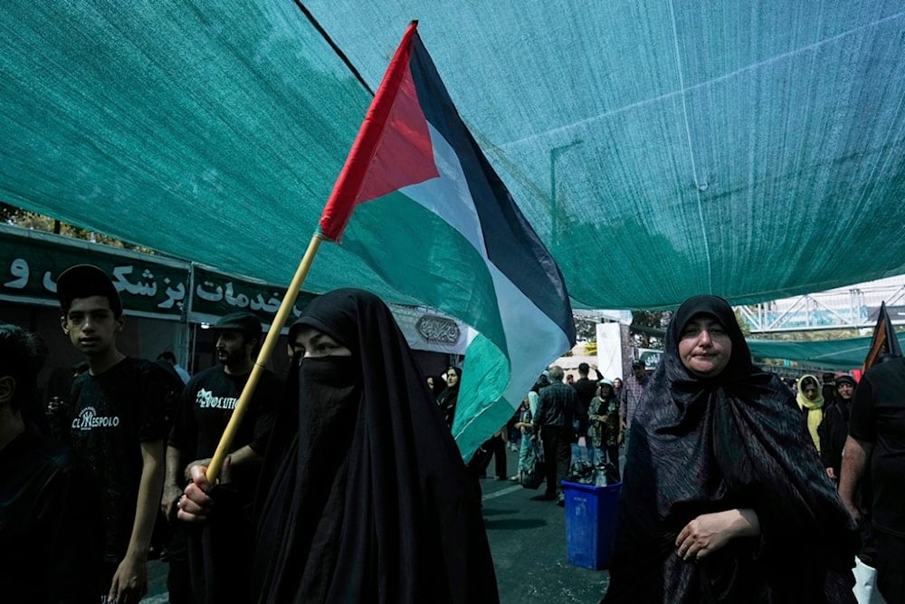 An Iranian woman carries a Palestinian flag in Shahr-e-Ray, south of Tehran, Iran, Thursday, August 14, 2025 (AP)