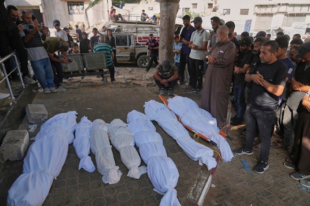 Palestinians pray over the bodies of people who were killed in an Israeli military strike, during their funeral outside Shifa Hospital, in Gaza City, Friday, August 22, 2025 (AP)