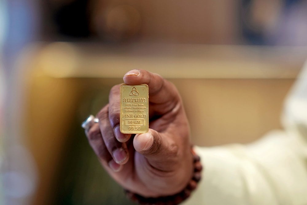 A jewelry shop owner shows a gold nugget at his store in Lucknow, India, Thursday, Aug. 7, 2025 (AP)