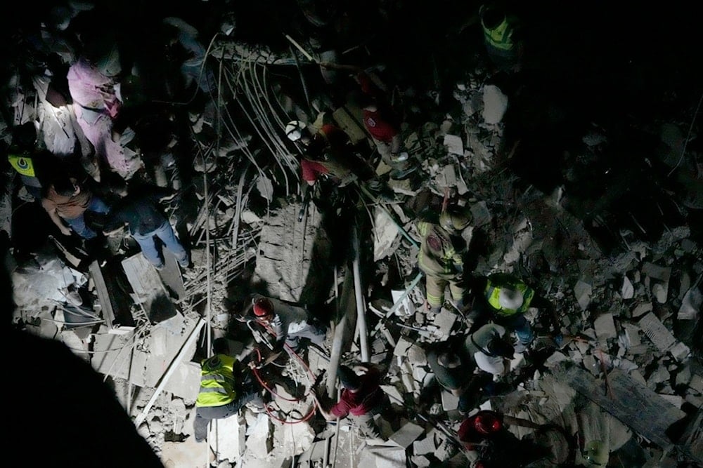 Civil defence workers check for victims between the wreckage of a destroyed building that was hit by an Israeli airstrike in the southern suburbs of Beirut, Lebanon, Tuesday, July 30, 2024 (AP)