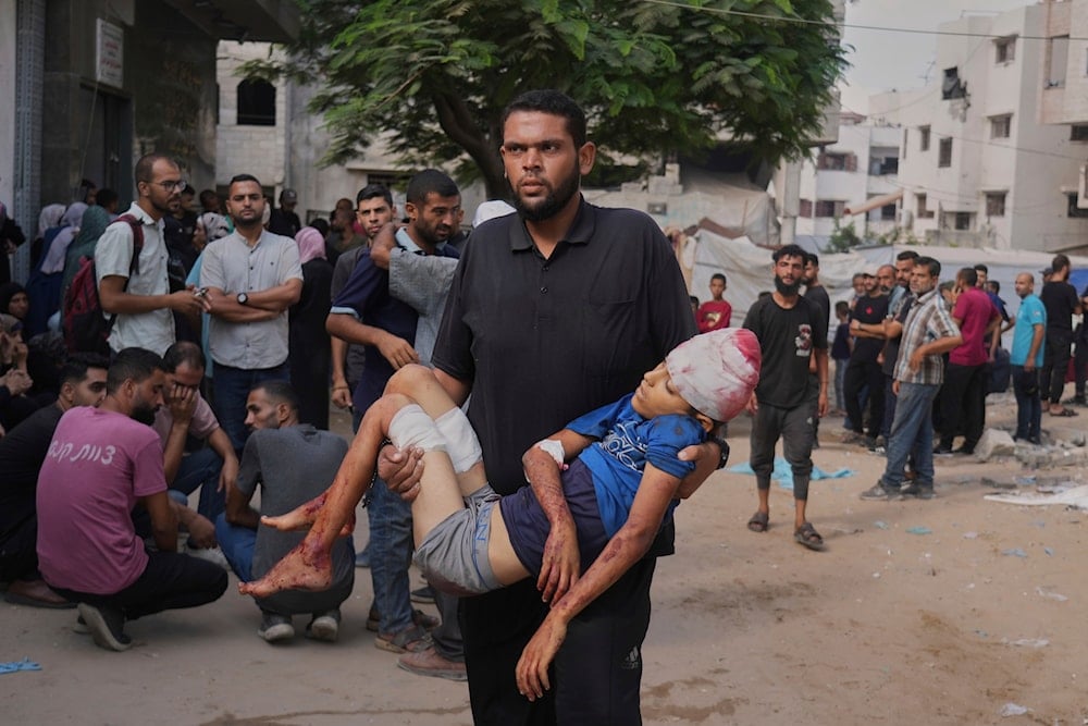  A man carries the body of Abdul Rahman, 12, a Palestinian child who was killed in an Israeli military strike in the Gaza Strip, as they arrive at Al-Shifa Hospital, Gaza City, Friday, Aug. 22, 2025 (AP)