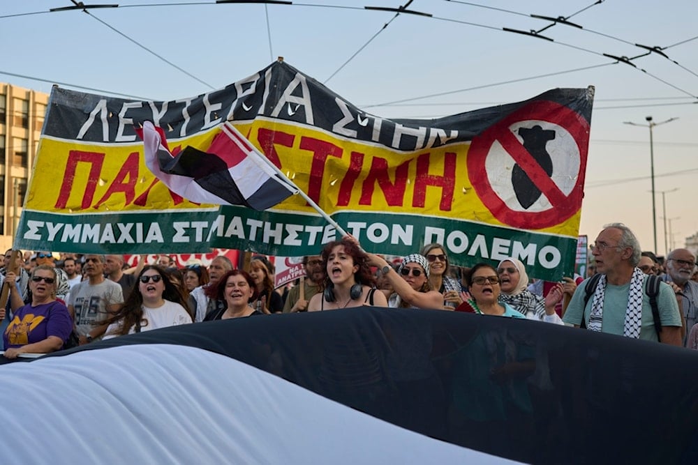 Protesters chant anti-Israeli slogans as they carry a banner that reads: