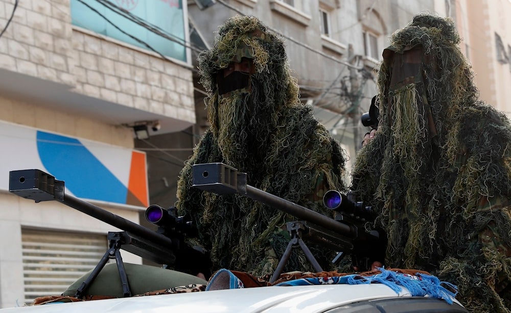 Masked soldiers from the al-Qassam Brigades, the military wing of Hamas, wear camouflage while sitting behind a sniper gun on the back of a truck in the streets of Nusseirat refugee camp, central Gaza Strip, Friday, May 28, 2021 (AP)