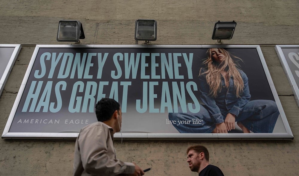 People walk past a campaign poster starring Sydney Sweeney which is displayed at the American Eagle Outfitters store, Friday, Aug. 1, 2025, in New York. (AP)