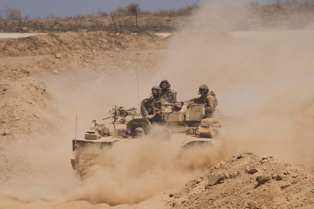 Israeli soldiers drive on their armored personnel carrier back from inside Gaza, Occupied Palestine, Tuesday, July 29, 2025 (AP)