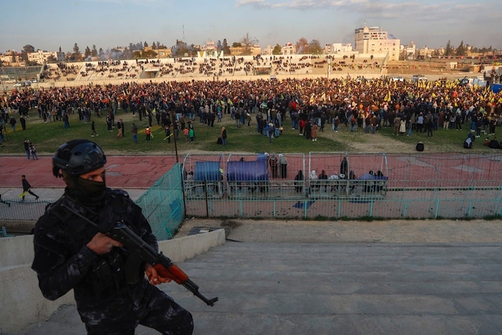 A Syrian Democratic Forces (SDF) fighter stands in guard as hundreds attend a gathering to listen a Pro-Kurdish Peoples' Equality and Democracy Party, or DEM, delegation in Qamishli, northeastern Syria, Thursday, February 27, 2025 (AP)