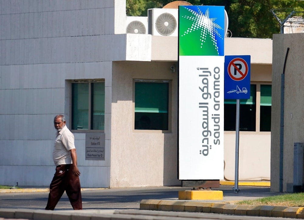 In this Nov. 3, 2019, file photo, a man walks past a compound for Saudi Aramco in Jiddah, Saudi Arabia (AP)
