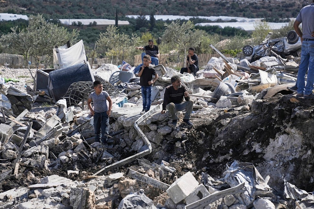 Palestinians gather at the site of an Israeli military raid in the West Bank village of Qabatiya, on Augsut 4, 2025. (AP Photo/Majdi Mohammad)