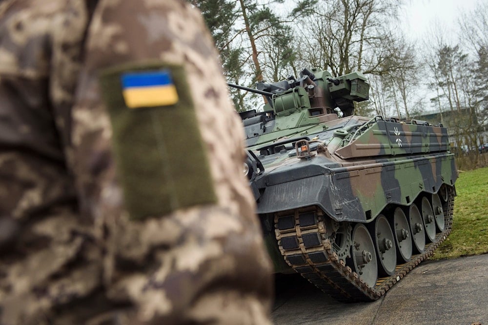 A Ukrainian soldier is standing in front of a Marder infantry fighting vehicle at the German forces Bundeswehr training area in Munster, Germany, on Feb. 20, 2023 (AP)