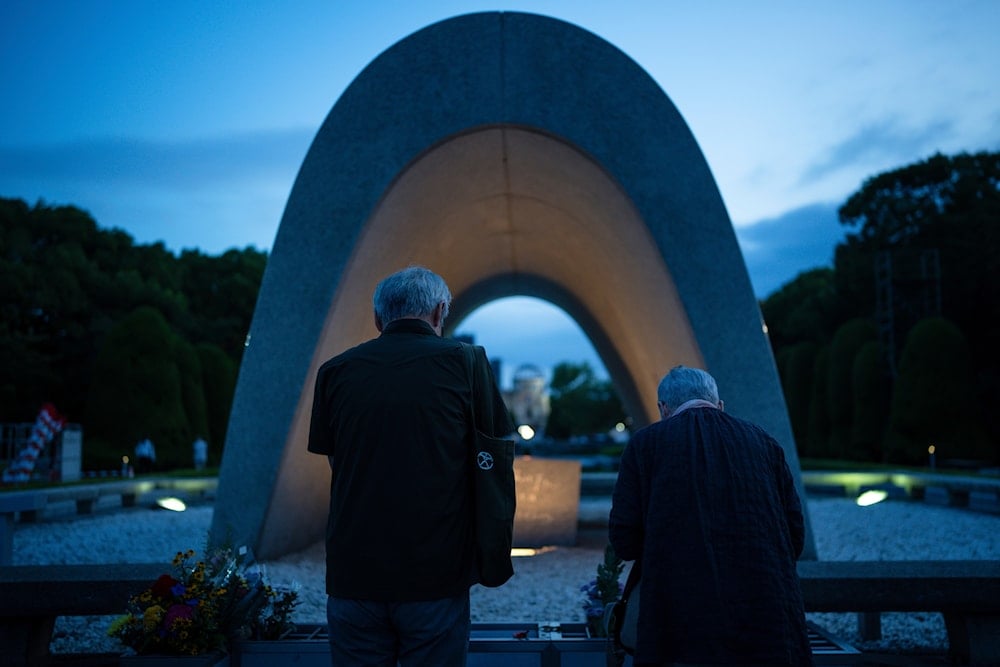 People pray for the atomic bomb victims in front of the Memorial Cenotaph ahead of the memorial service to mark the 80th anniversary of the WWII U.S. atomic bombing in Hiroshima, on August 6, 2025, in Japan. (AP Photo/Louise Delmotte)