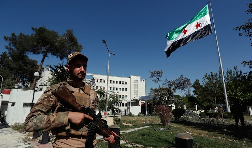 Syrian soldiers raise the Syrian national flag in front of the Syrian Defense Ministry building, which was heavily damaged by Israeli airstrike, in Damascus, Syria, Saturday, July 19, 2025. (AP)