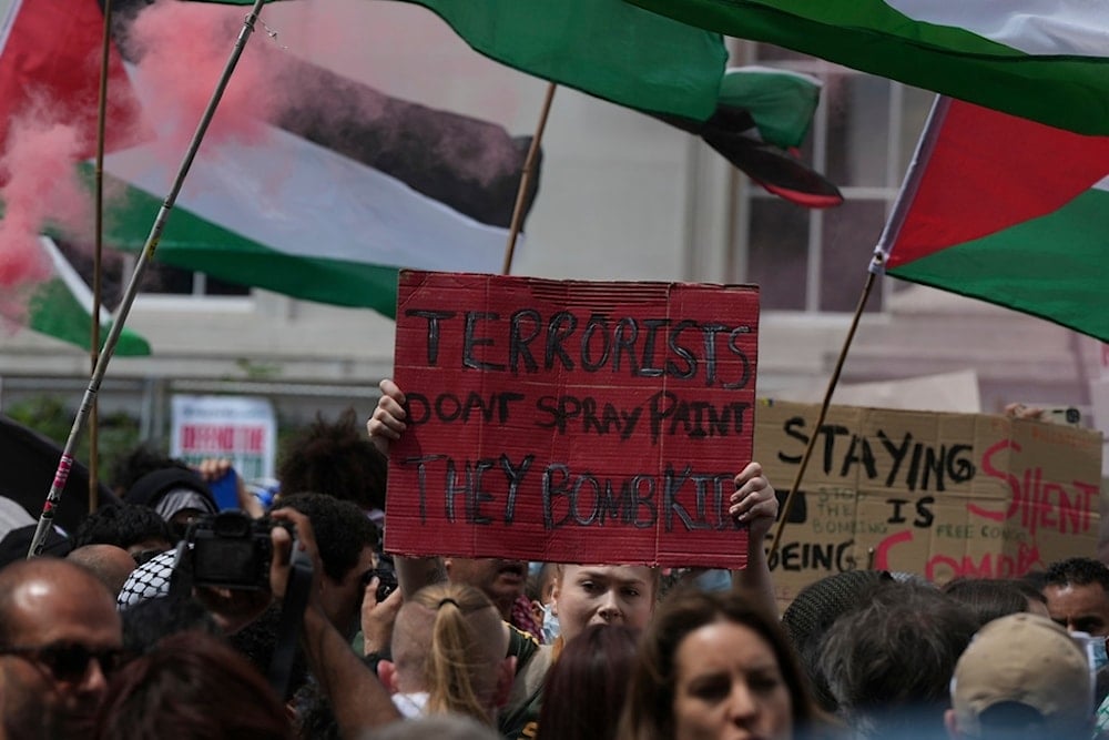 A demonstrator hold up a red painted placard during a protest by Palestine Action group in London, Monday, June 23, 2025. (AP Photo/Frank Augstein)