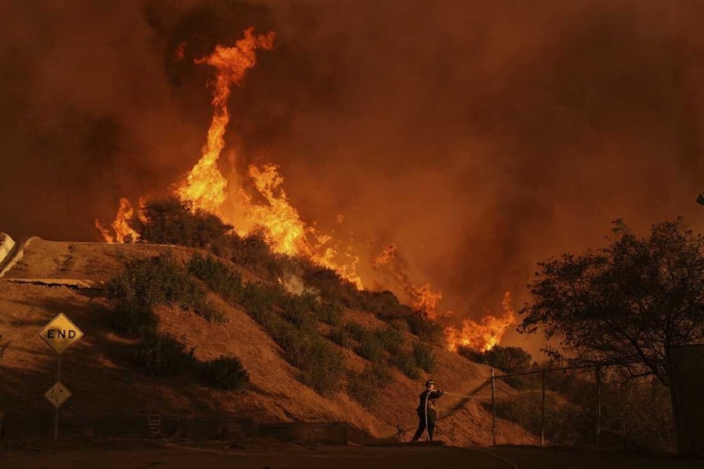 A firefighter battles the Palisades Fire in Mandeville Canyon, north of the Brentwood neighborhood, on Saturday in Los Angeles. (Jae C. Hong/AP)