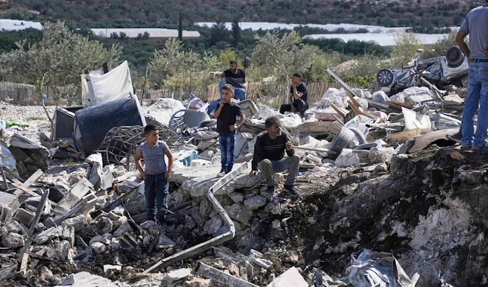 Palestinians gather at the site of an Israeli raid in the West Bank village of Qabatiya, Monday, Aug. 4, 2025. (AP)
