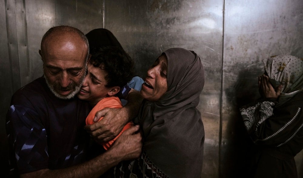Raed Salem Aslyieh hugs his relatives after the death of his son, Ahmed Raed Aslyieh, 18, who succumbed to injuries sustained in an Israeli strike that killed eight other family members, at Shifa Hospital in Gaza City, Aug. 6, 2025 (AP)