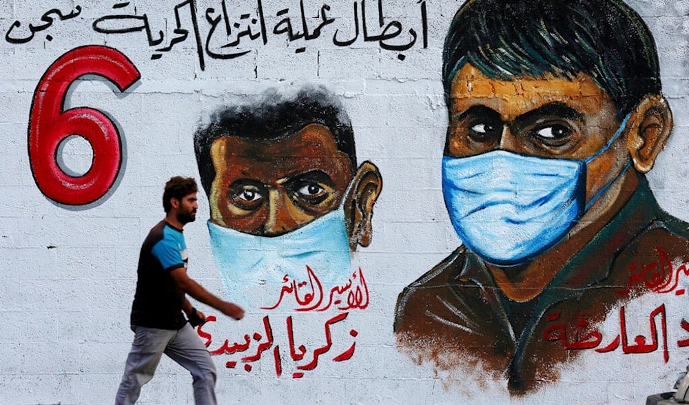 A resident walks next to a mural painting glorifying six Palestinian prisoners who tunneled out of Gilboa Prison almost two weeks ago, and were arrested by Israeli forces, in Gaza City, Thursday, Sept. 23, 2021. (AP)