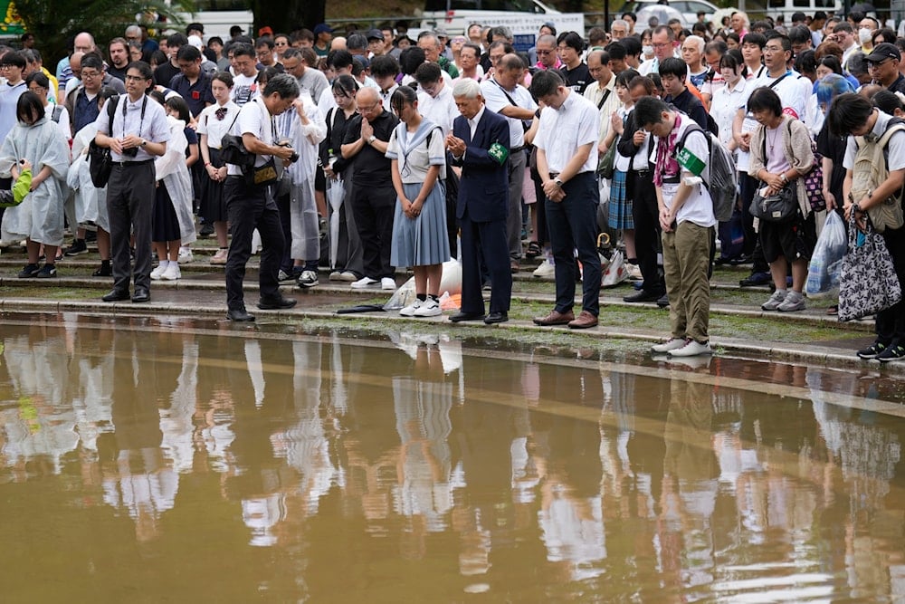 People observe a minute of silence at the Atomic Bomb Hypocenter Park, during a ceremony to commemorate the 80th anniversary of the day an atomic bomb was dropped on Japanese southwestern city, in Nagasaki, Japan Saturday, Aug. 9, 2025 (AP)