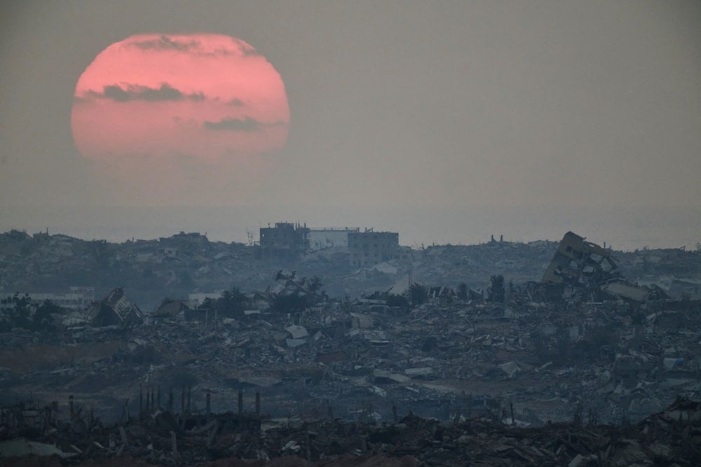 The sun sets behind buildings that were destroyed during the Israeli ground and air operations stand in the northern Gaza Strip, Occupied Palestine, Friday, Aug. 8, 2025 (AP)