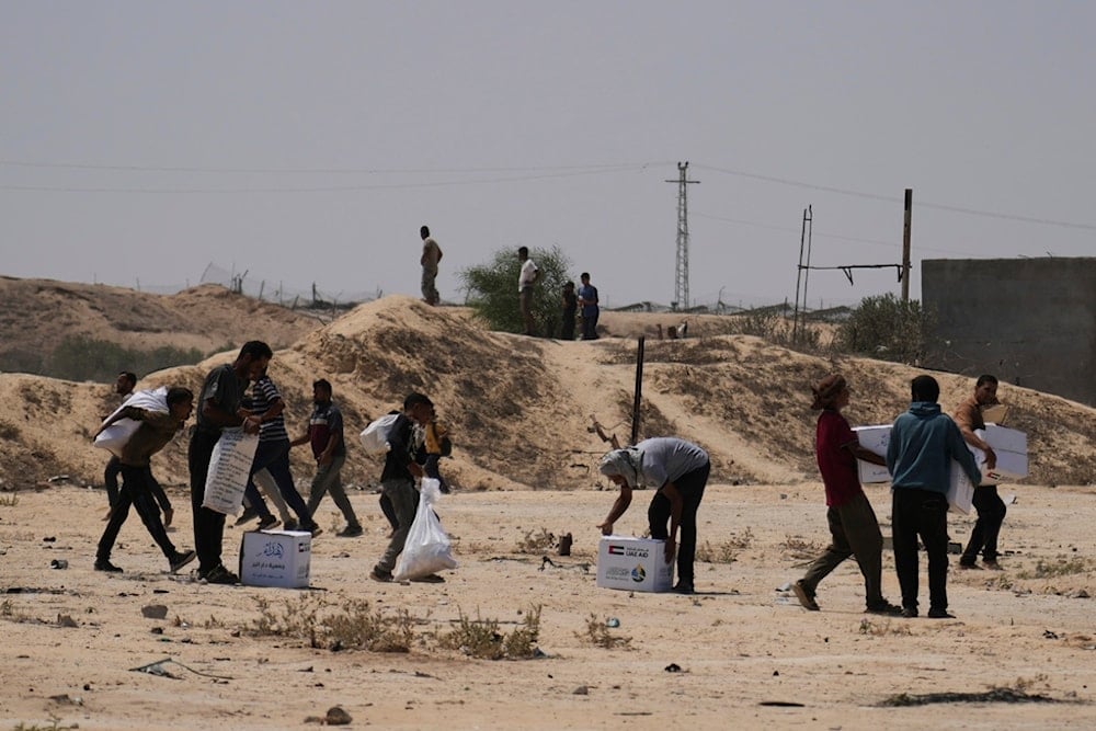 Palestinians collect humanitarian aid packages from the United Arab Emirates after they were airdropped into Deir al-Balah, in central Gaza Strip, Saturday, Aug. 9, 2025. (AP)