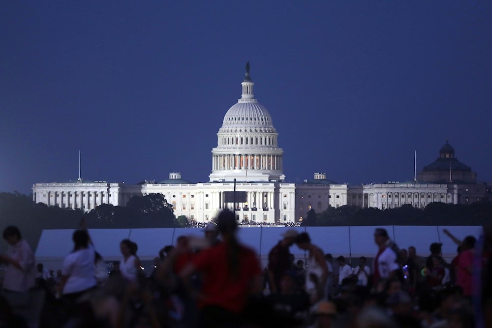 The U.S. Capitol building stands as people wait to watch fireworks near the Washington Monument during Fourth of July celebrations, in Washington, on July 4, 2025. (AP Photo/Rahmat Gul)
