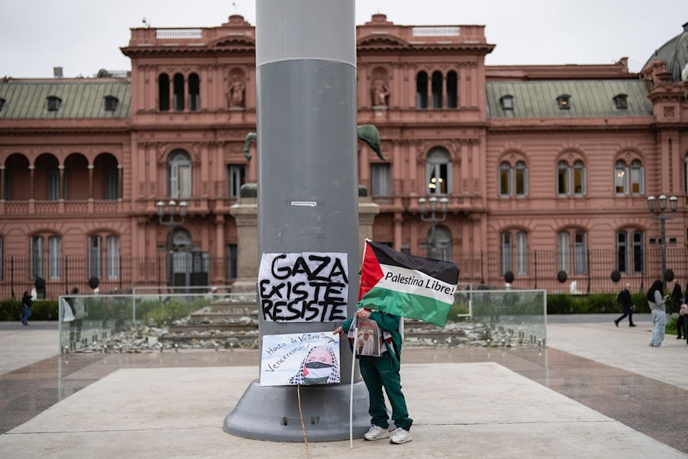 A protester holds a flag that reads in Spanish, 