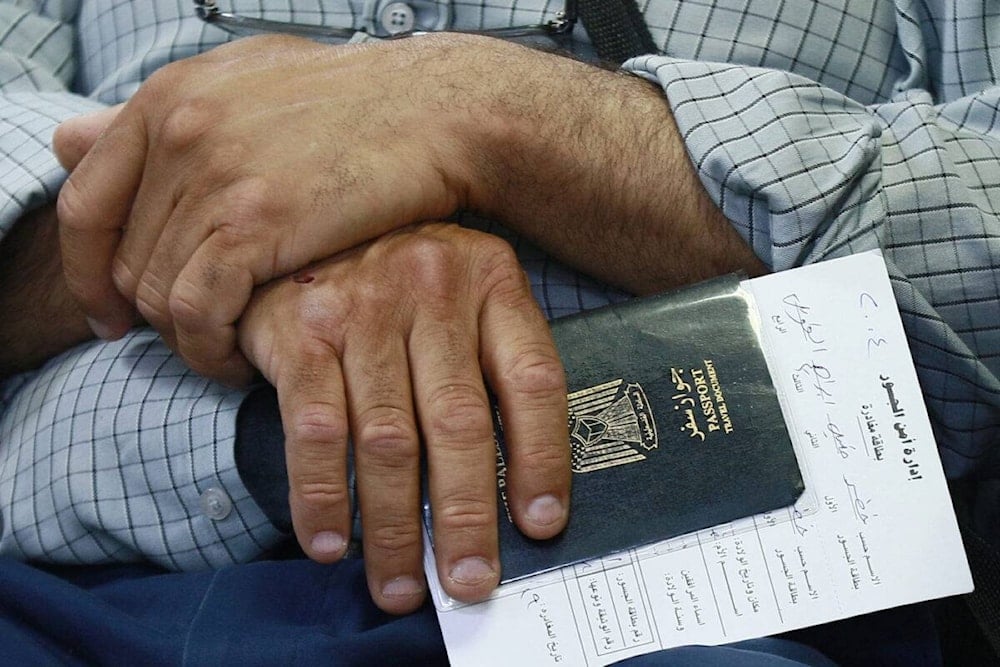 A passenger, holding his Palestinian passport, sits in a waiting room on the Jordanian side of the King Hussein Bridge crossing between the West Bank and Jordan on July 19, 2022 (KHALIL MAZRAAWI/AFP via Getty Images)