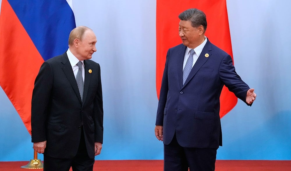 Chinese President Xi Jinping, right, shows the way to Russian President Vladimir Putin after a photo session of the SCO summit at the Meijiang Convention and Exhibition Centre in Tianjin, China, Monday, Sept. 1, 2025. (AP)